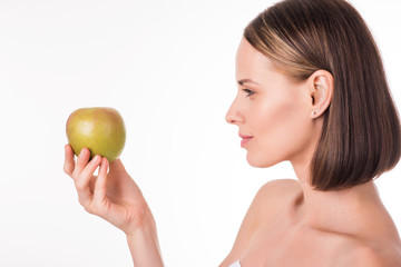 Obraz na płótnie Canvas Positive young woman holding green apple