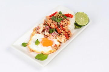 Rice topped with stirred  minced-pork ,squid ,basil and fried egg(sunny up) on white background.