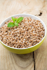 Buckwheat porridge in a bowl with mint leaves and blueberries.