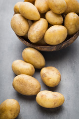 New potato on the bowl, gray background.