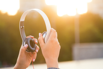 Headphones in a nice hands at sunset . Beautiful light .