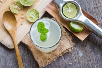 Green lemon juice on wooden background, rustic style