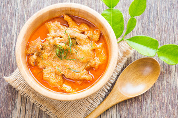 Panang Curry with Pork on wooden table, Thai food with rustic style.