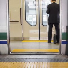 Door of commuter train, with a businessman.
