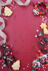 Christmas background with ornaments on red wood table.