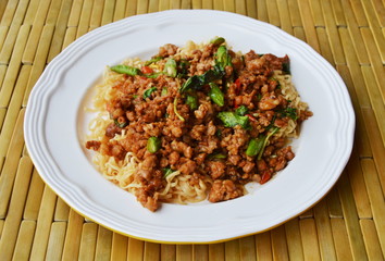instant noodle topping spicy stir fried chop pork and basil leaf on dish