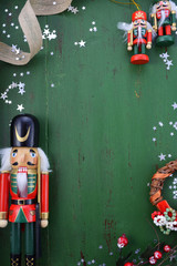 Christmas background with ornaments on green wood table.