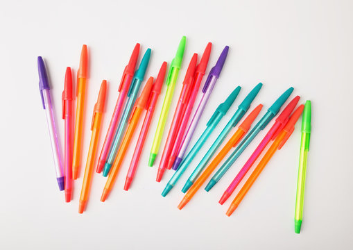 ballpoint pens of different colors on a white background