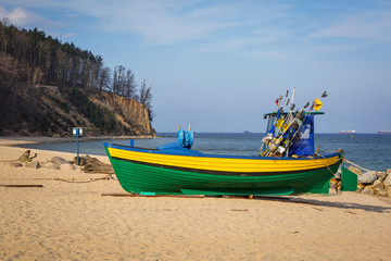 Naklejka na ściany i meble Baltic beach with fishing boat at Orlowo cliff, Poland
