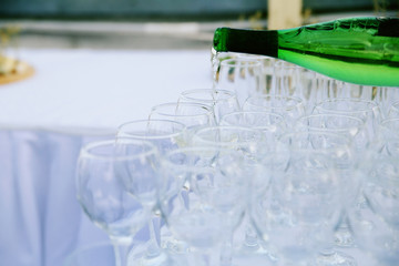 The waiter pours wine into glasses