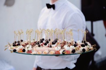 waiter holding a dish of snacks