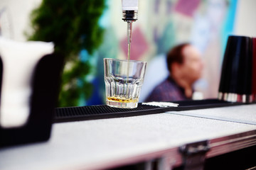 Bartender pouring whiskey into a glass