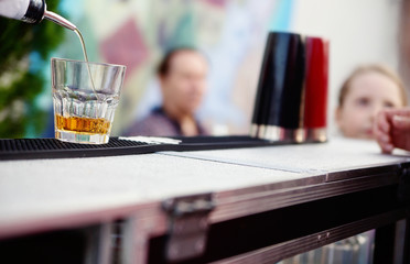 Bartender pouring whiskey into a glass