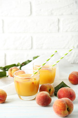 Glasses of peach juice on white wooden table