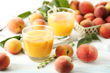 Glasses of peach juice on white wooden table