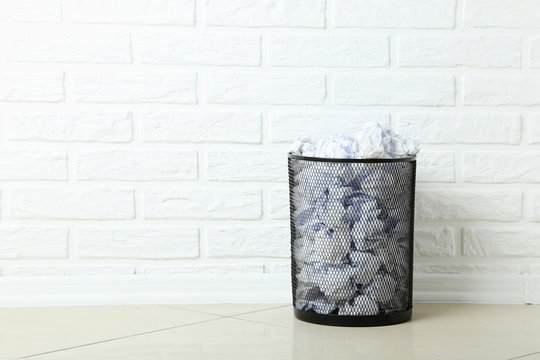 Office trashcan with crumpled paper balls