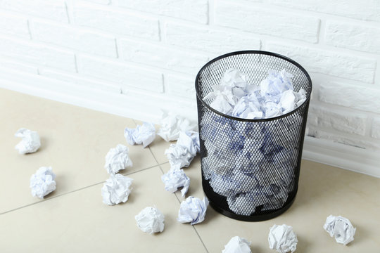 Office trashcan with crumpled paper balls