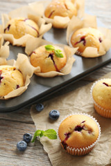 Muffins with blueberries on grey wooden table