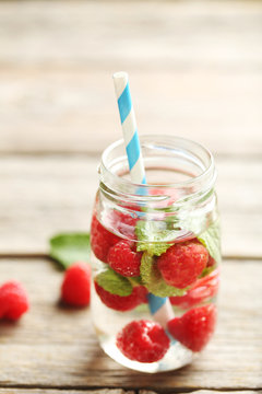 Detox water in bottle with berries on wooden table