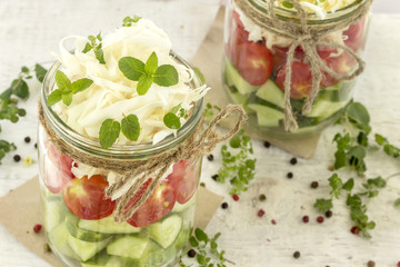 Cucumbers, tomatoes and cabbage in a glass jar