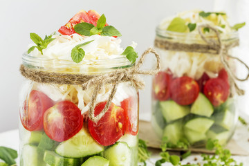 Cucumbers, tomatoes and cabbage in a glass jar
