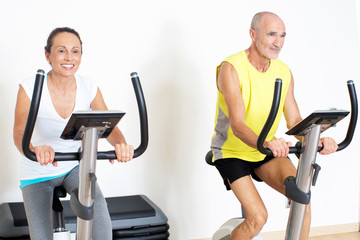 senior couple on indoor bike during spinning exercise