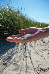 Sand rieselt durch Hand