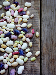 young beans of different varieties and colors with a side border on a wooden background. selective focus