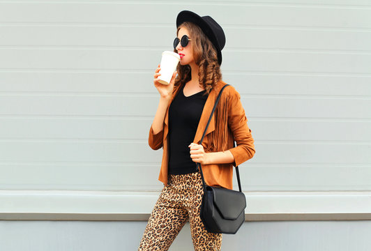 Fashion pretty young woman drinks coffee of cup wearing a retro