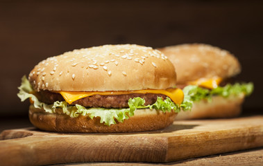 Fresh burgers on wooden background