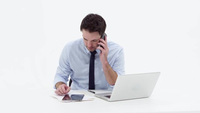 Businessman using laptop,talking on phone and smiling