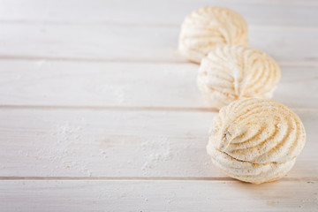  close up sweet zephyrs on white wood background.   Bakery products.