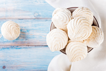Plate of tasty zephyr on blue  wooden table, close up. sweet zephyrs on wood background.