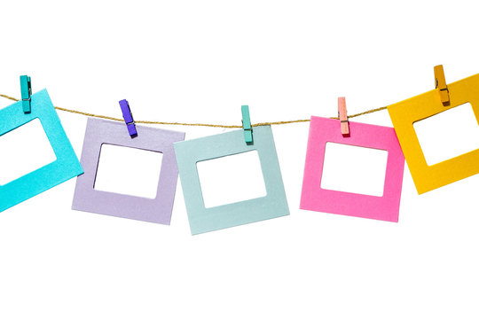 Colorful funny picture frames hanging on a rope with clothespins twine isolated on white background
