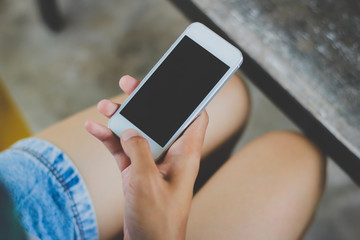 Woman use mobile phone in coffee shop from backside view.