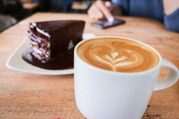 Coffee cup and chocolate cake on wood table  background.