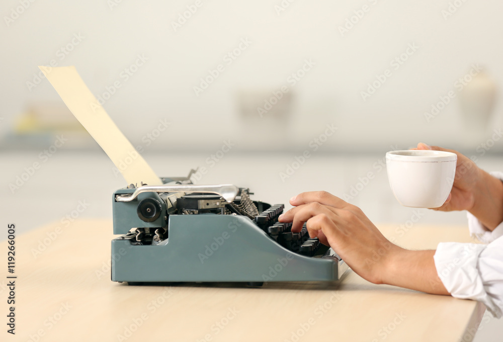 Poster man working on retro typewriter at desk
