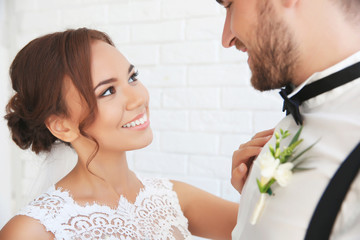 Obraz na płótnie Canvas Groom and bride on white brick wall background