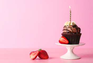 Tasty chocolate cupcake with berries on pink background