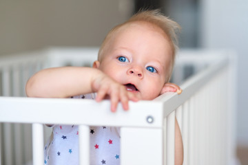 Baby boy standing in crib