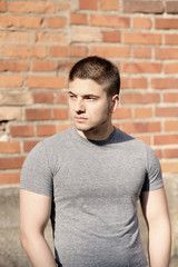 Young man in front of brick wall