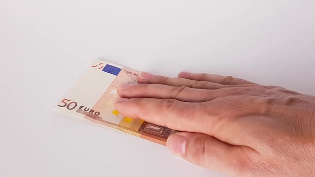 50 Euro werden von einer m&auml;nnlichen Hand auf einen Tisch geschoben
