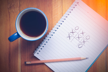 XO Game and coffee cup on wood background