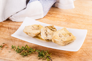 Artichokes hearts with herbs on cutting board