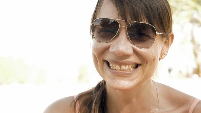 Woman is laughing expressively and emotionally. Hoots of laughter is a permanent attribute of enjoying a good company and relaxation outdoors. Positive emotions and happiness concept.