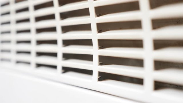 Domestic device room heating grille close-up shallow DOF slow tilt 4K 3840X2160 UltraHD video - Electric convector home heat radiator exchanger grill 4K 2160p 30fps UHD tilting footage 