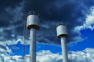 Water towers under cloudy sky