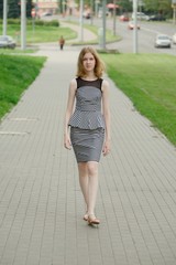 Pretty young teenage girl in striped dress on city street