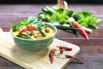 Green curry with fish ball in green chalice on wooden table