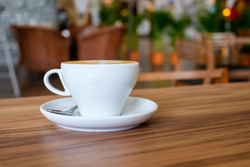 White mug cup of hot coffee on wooden table